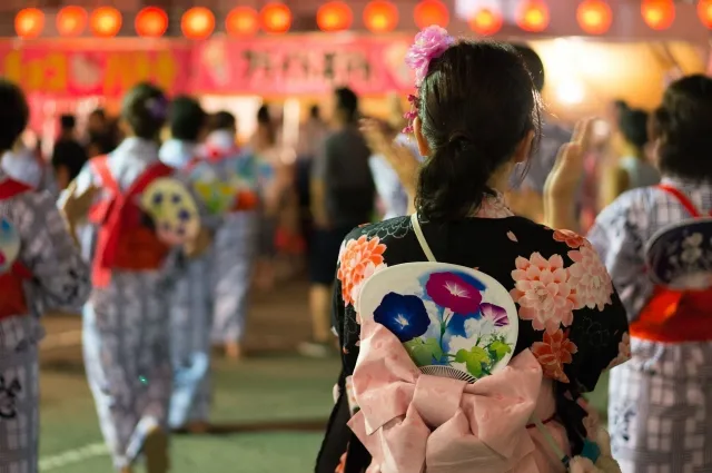 夏休みに浴衣姿で盆踊りを楽しむ女性